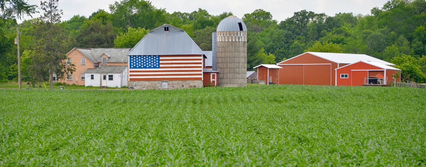 A farm with the USA flag displayed on a barn