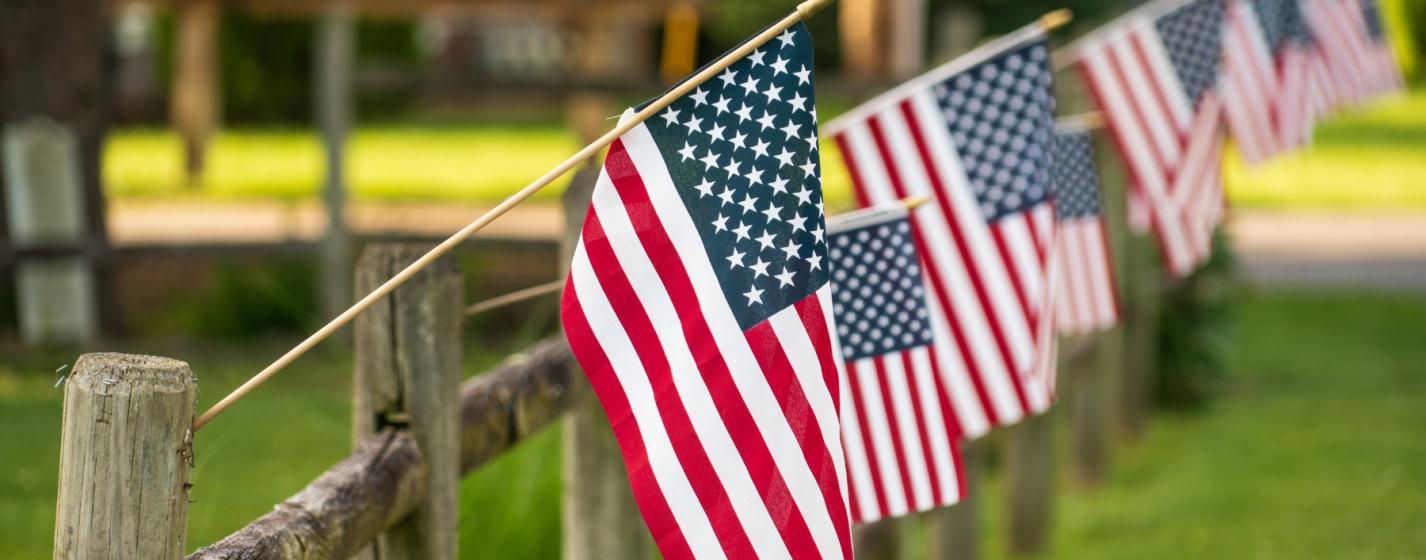 American flags on a wooden fence