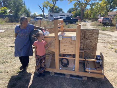A mother and daughter looking at a fanning mill