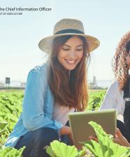 Two women looking at a tablet in a garden with the OCIO logo overlay