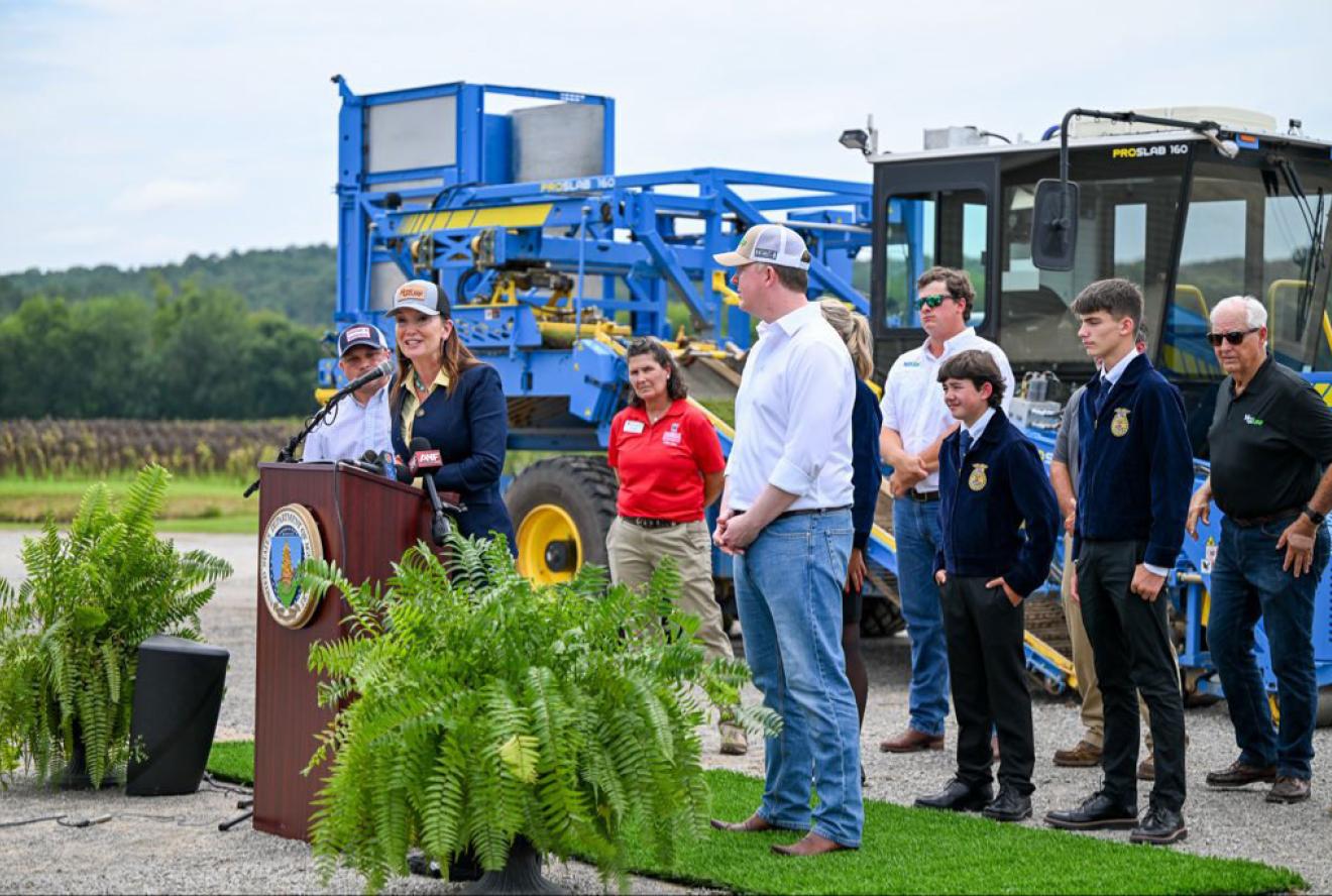 Secretary Rollins speaking at a podium