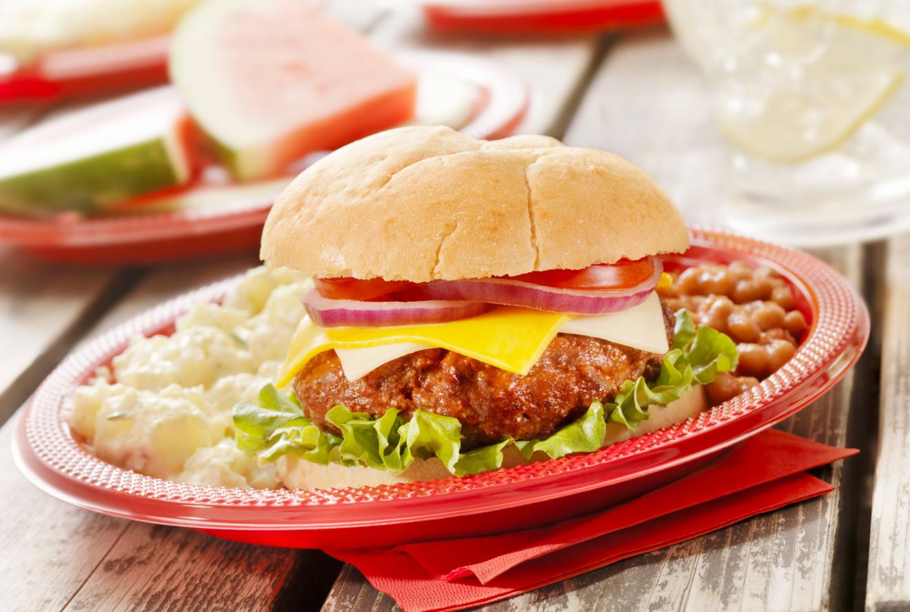 A hamburger, beans and potato salad on a plate